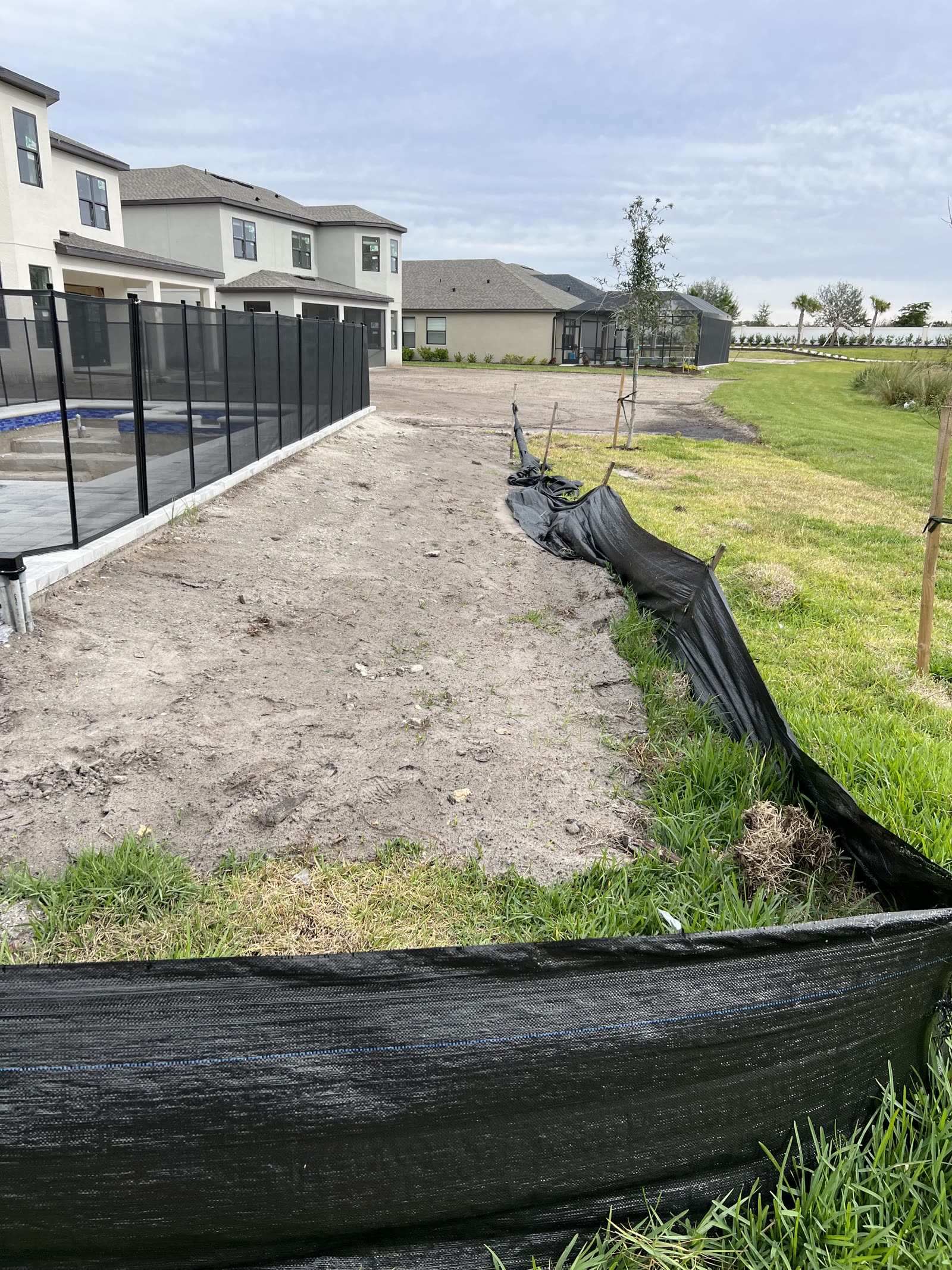 Before — North Port backyard — bare lot transformed into a landscaped pool deck with fresh sod and mulch