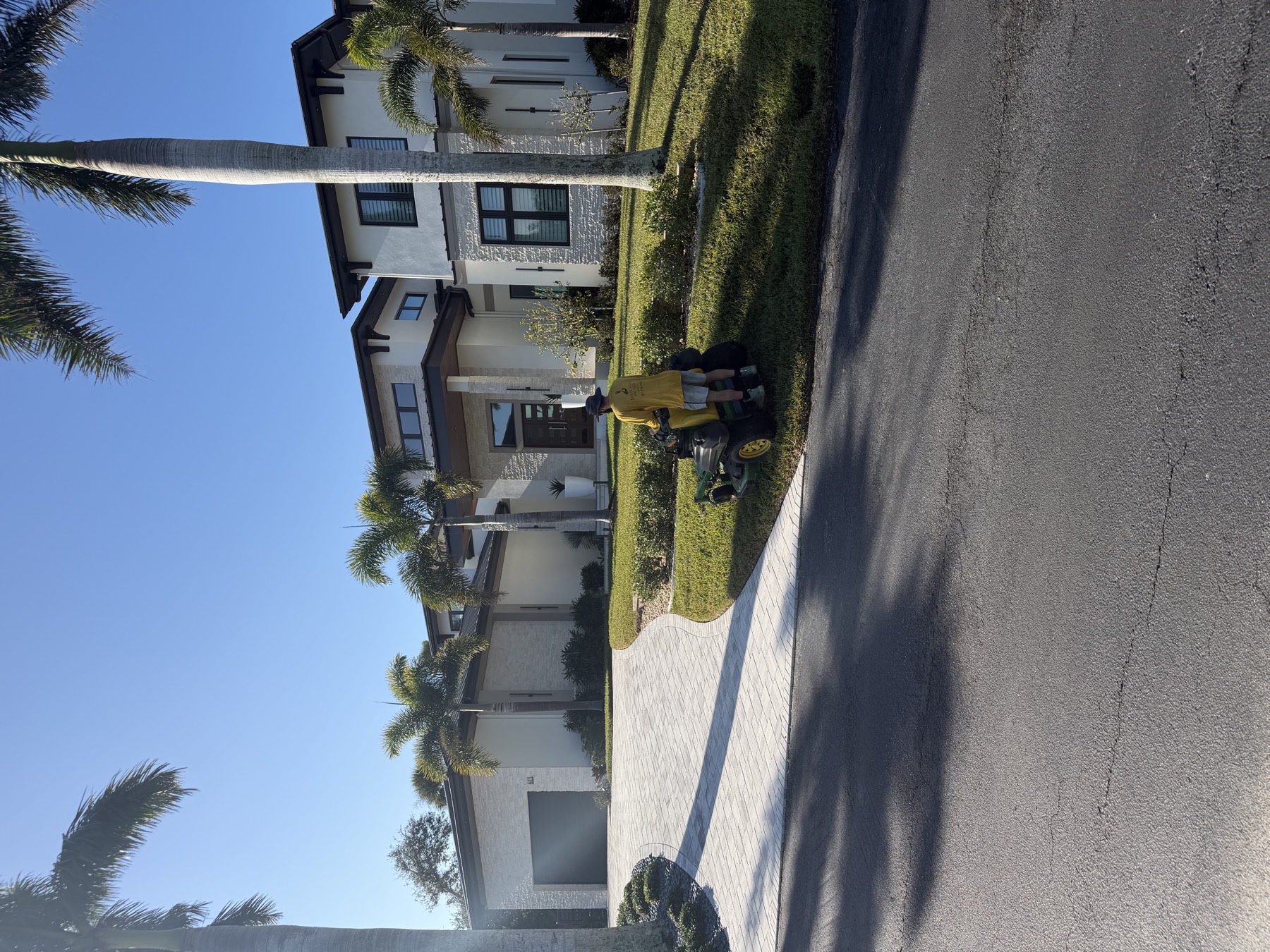 The Plants' Pruner crew mowing a palm-lined estate lawn in Sarasota County