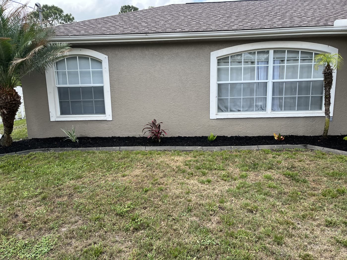 Freshly mulched foundation bed and healthy lawn at a North Port home
