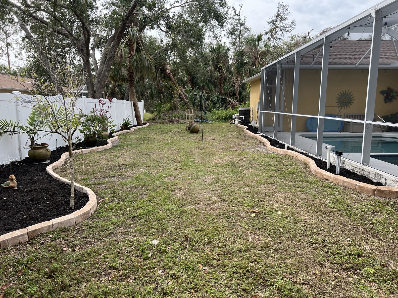 After — North Port backyard — patchy lawn finished with a curved mulch border and new plantings
