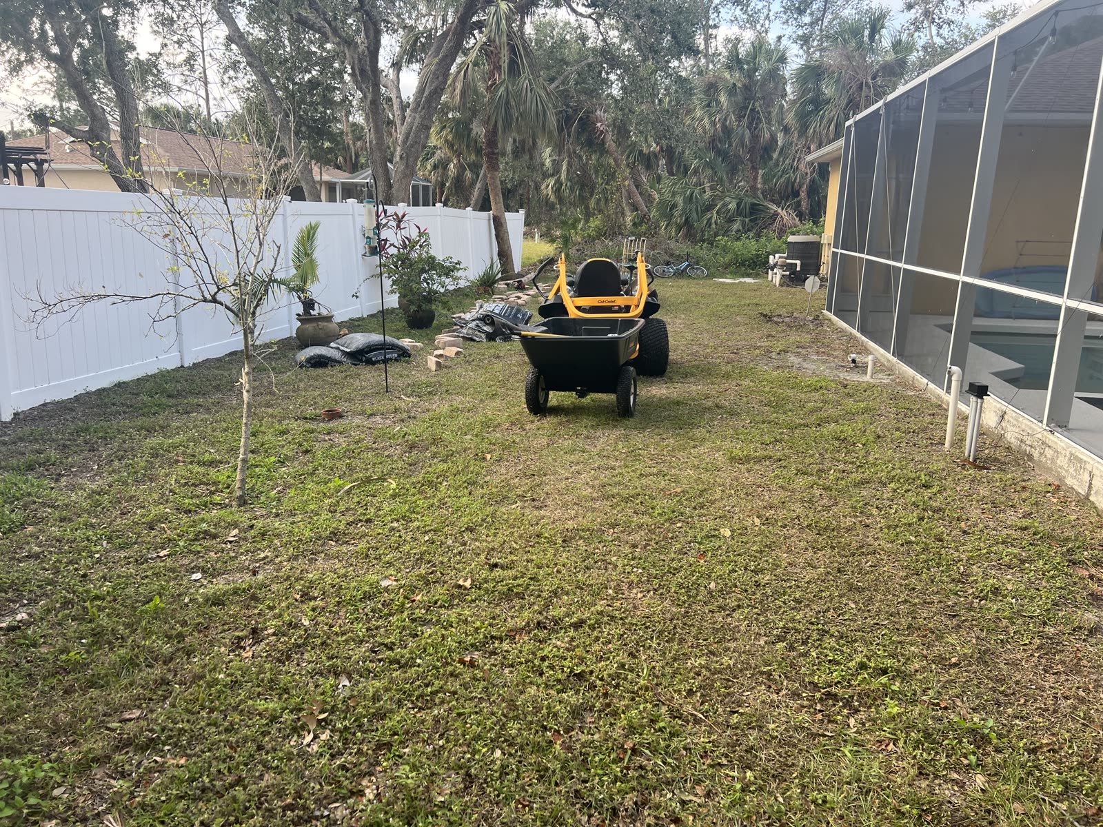 Before — North Port backyard — patchy lawn finished with a curved mulch border and new plantings