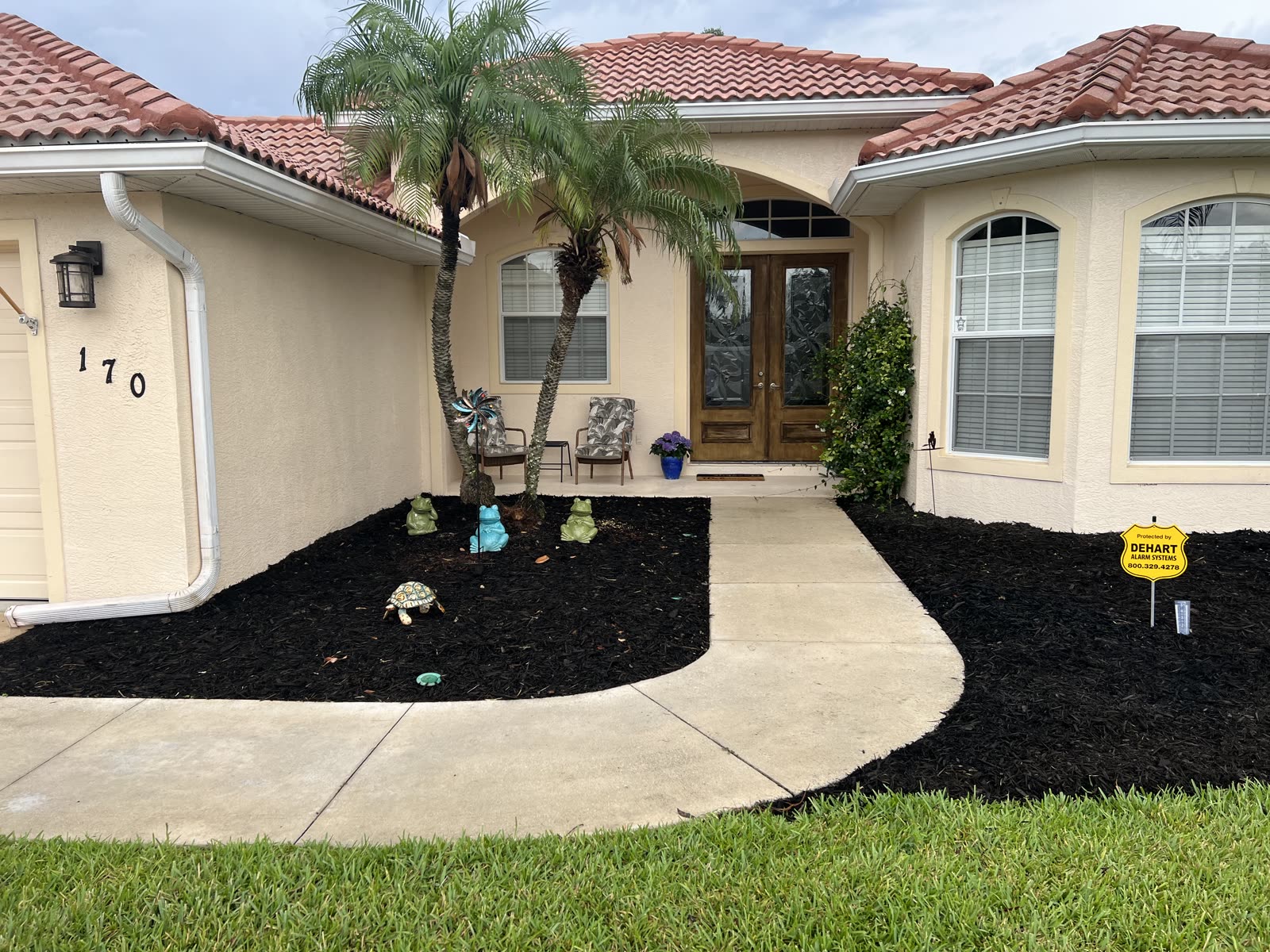 After — North Port home — overgrown beds restored with fresh mulch and trimmed hedges