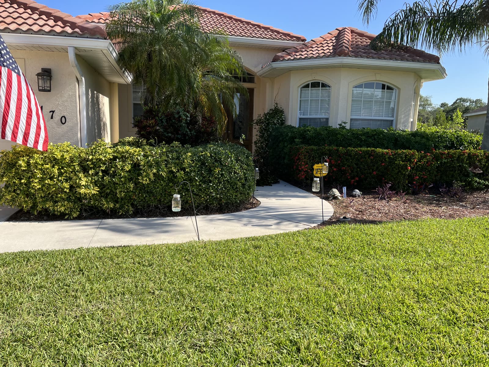 Before — North Port home — overgrown beds restored with fresh mulch and trimmed hedges